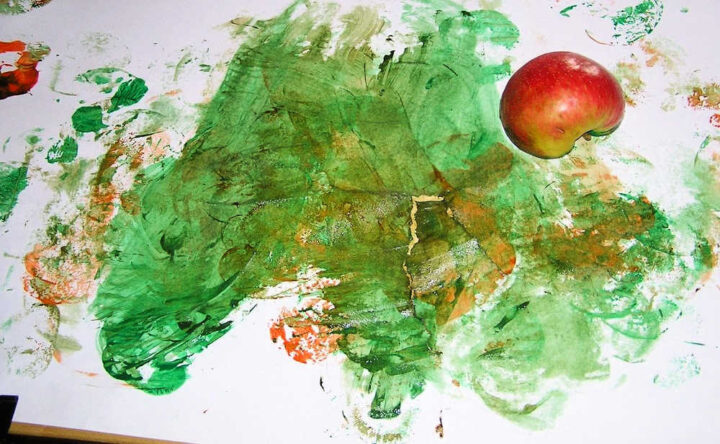 Apple half on paper covered in green paint