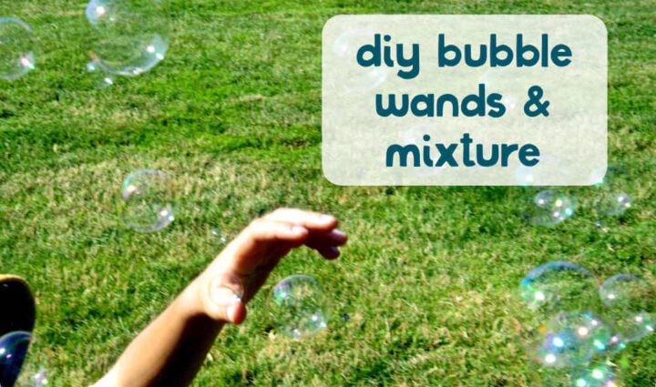 Child's had catching bubbles in the grass