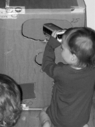 Boy placing toy bus into diy carnival game box