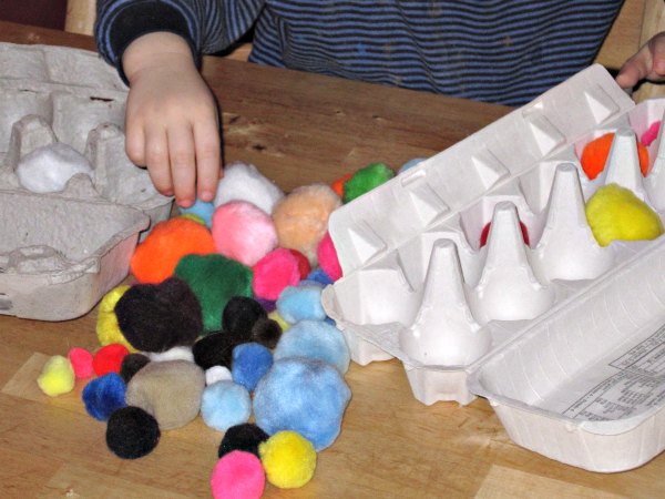 Toddler activity with egg cartons and pom poms