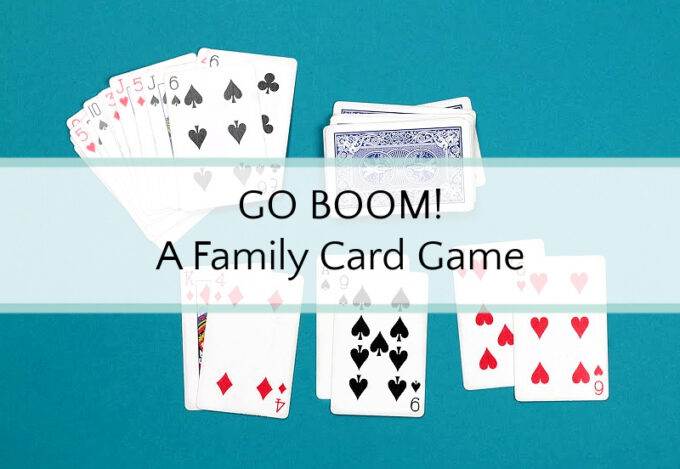 Playing cards face up in four stacks, on stack face down on blue background with Go Boom A Family Card Game overlayed