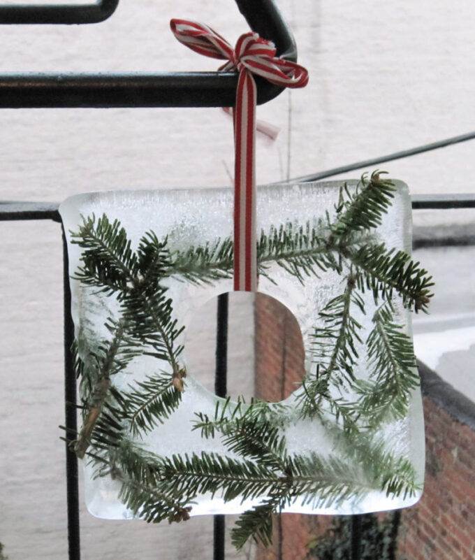 ice wreath with pine needles and red ribbon