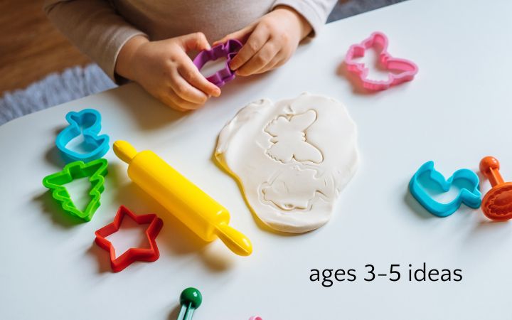 Child's hand playing with play dough and cookie cutters