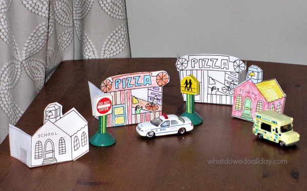 school and pizza parlor coloring page templates set up on table with toy cars and toy street signs
