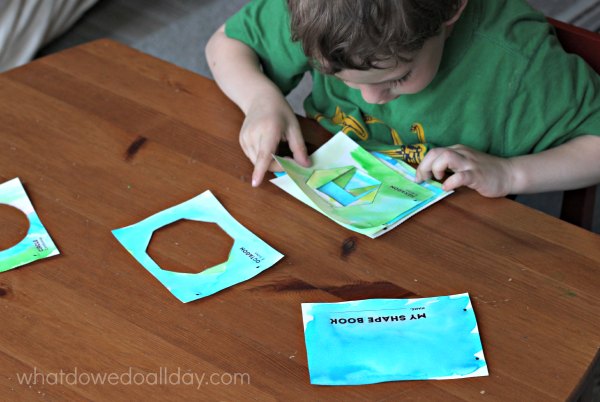 Child putting together a shape book art project. 