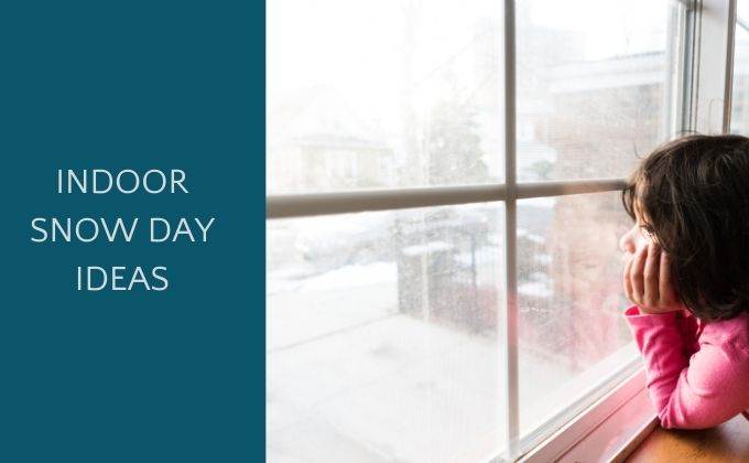 child looking out of window at snow