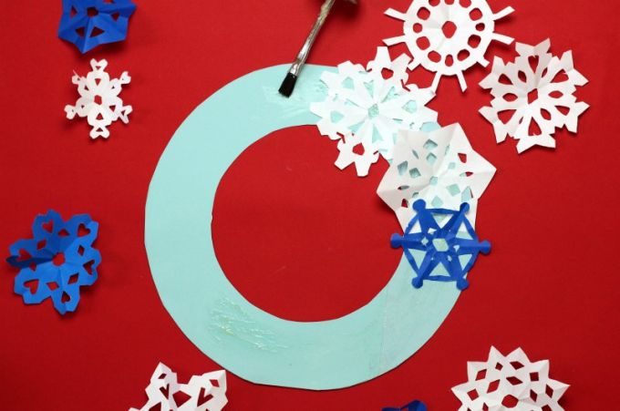 Glue snowflakes onto winter holiday wreath
