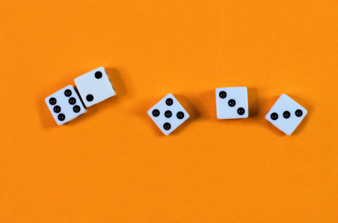 Five white dice on orange backdrop