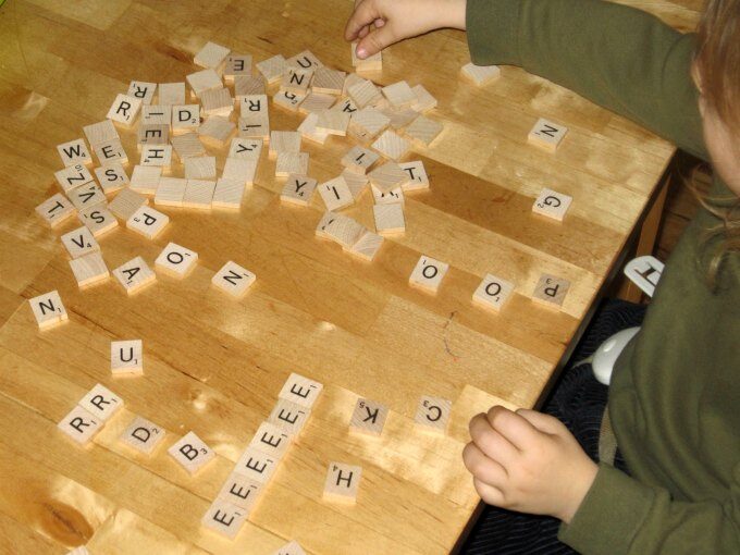 toddler playing with scrabble pieces