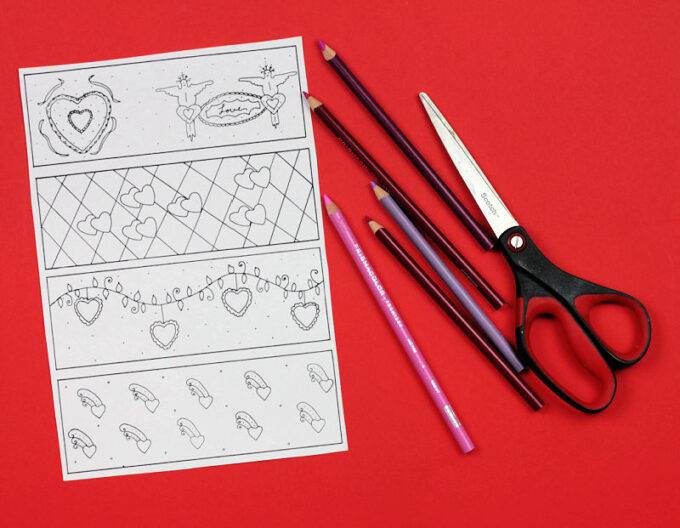 black and white coloring page showing four valentine bookmarks next to scissors and colored pencils