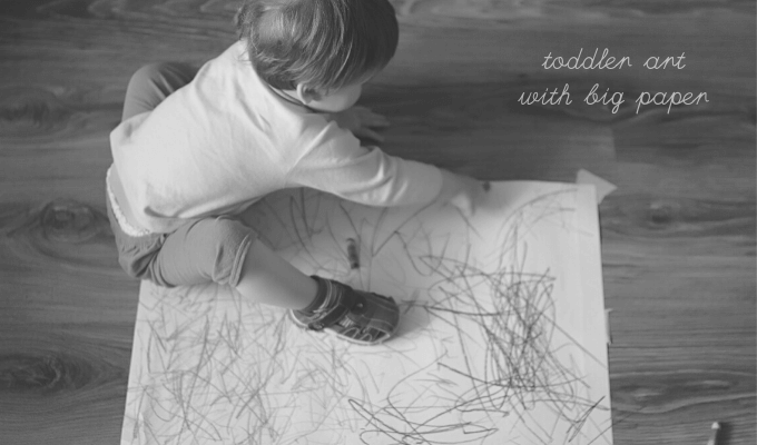 Toddler drawing on big roll of paper